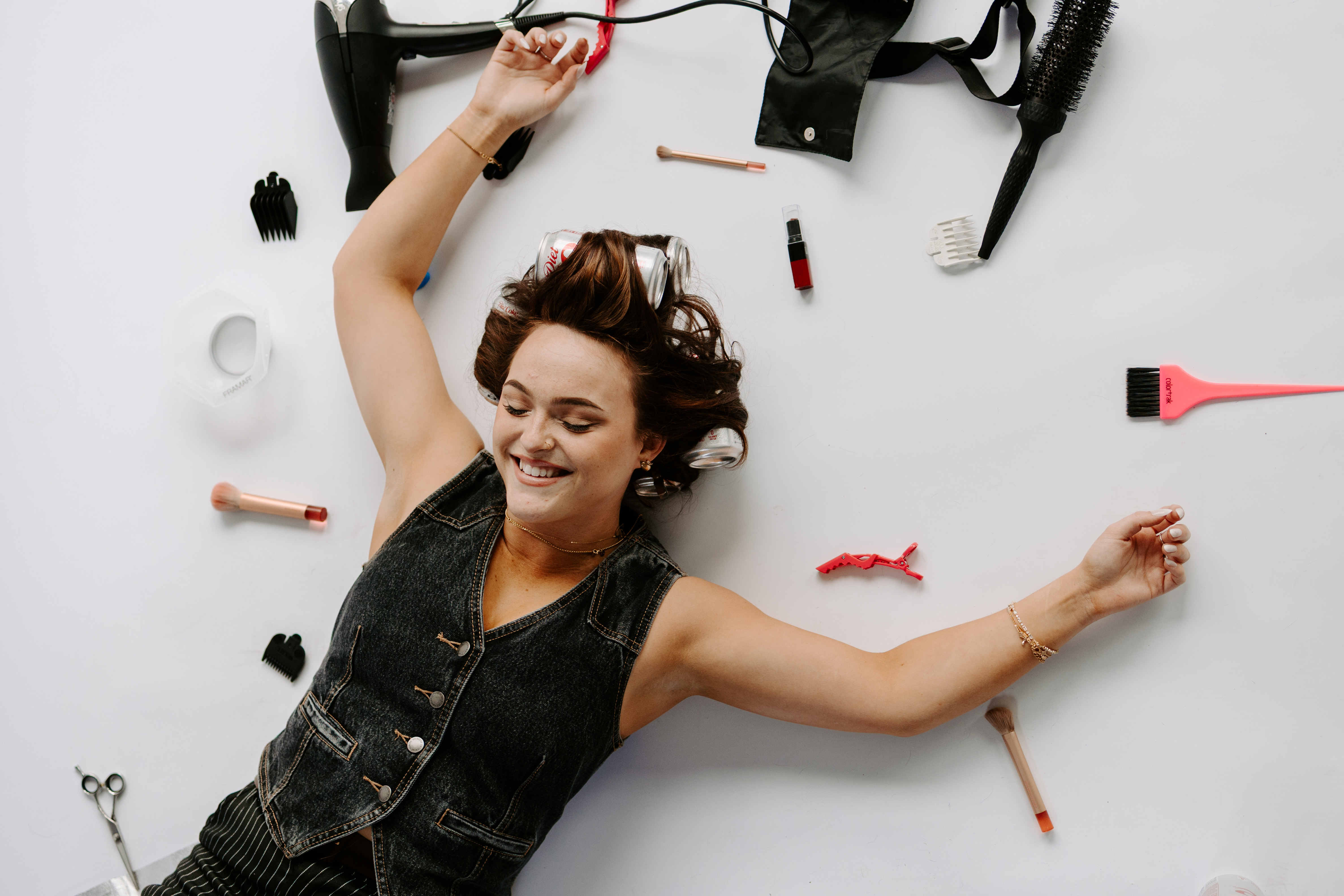 Paige laying down with hairstylist accessories